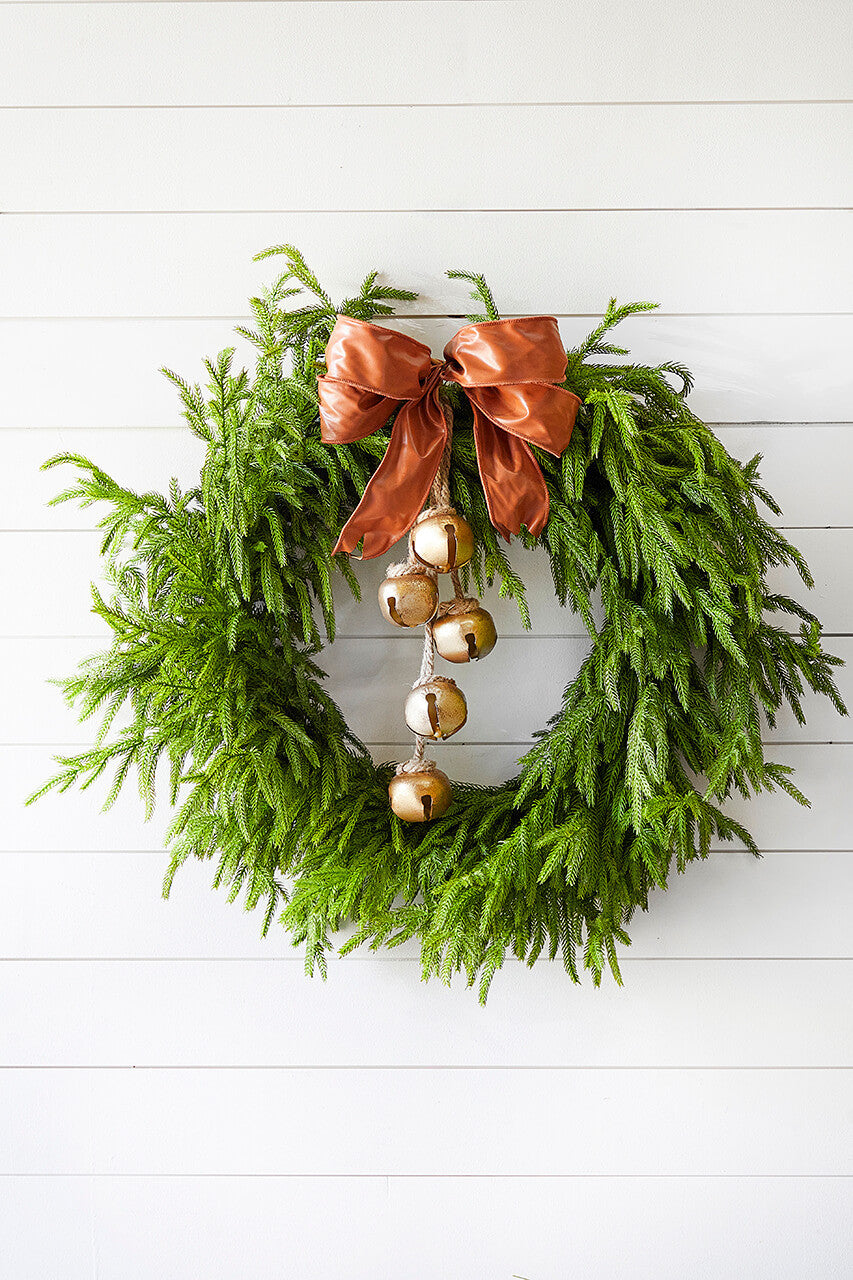 Green faux pine Christmas wreath with a copper bow and gold ornament accents.