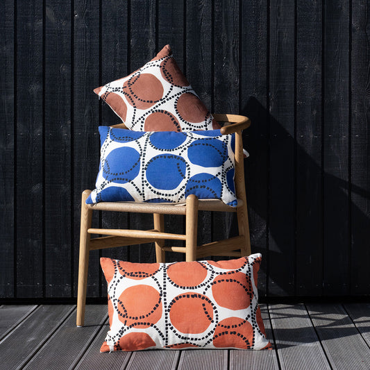 Small lumbar pillow with geometric circles in blue, orange, and white