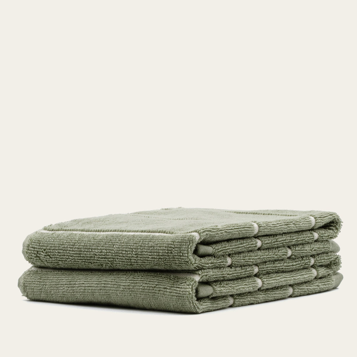 Sage green cotton towels, multiple stacked with plush terry finish