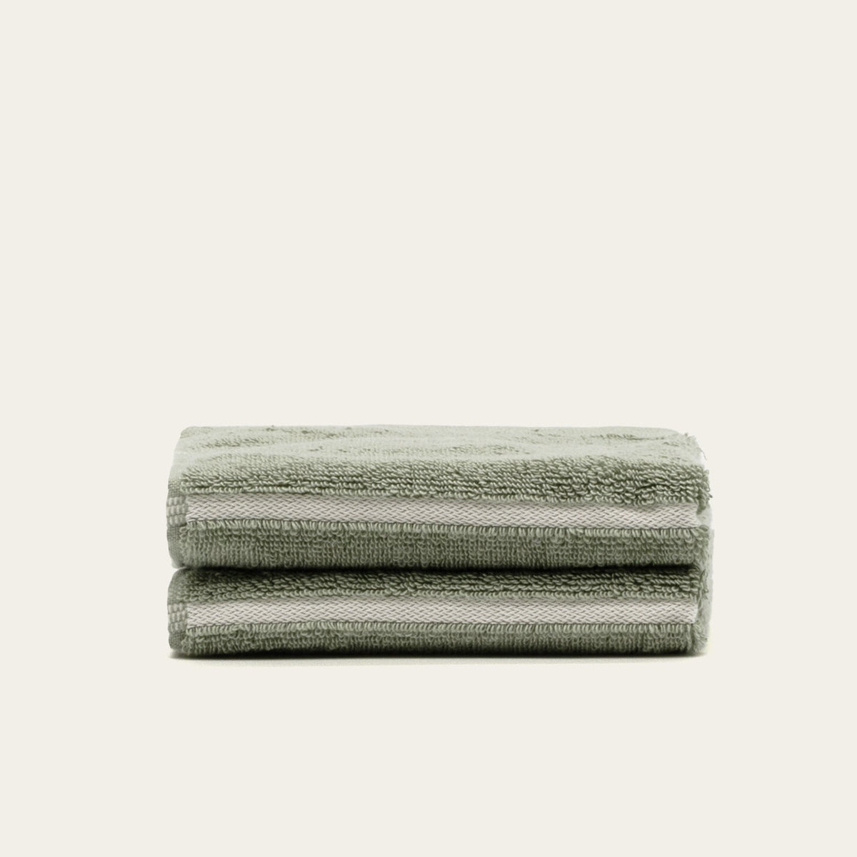 Sage green and ecru cotton towels with thin border stripes, folded stack