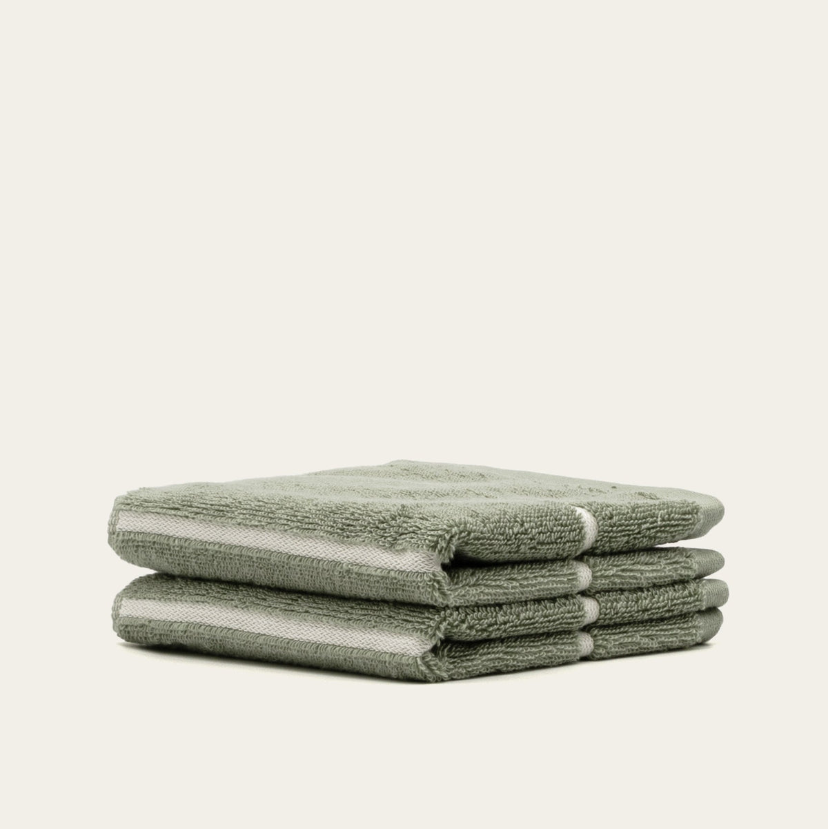 Sage green cotton towels with textured terry loops, folded stack