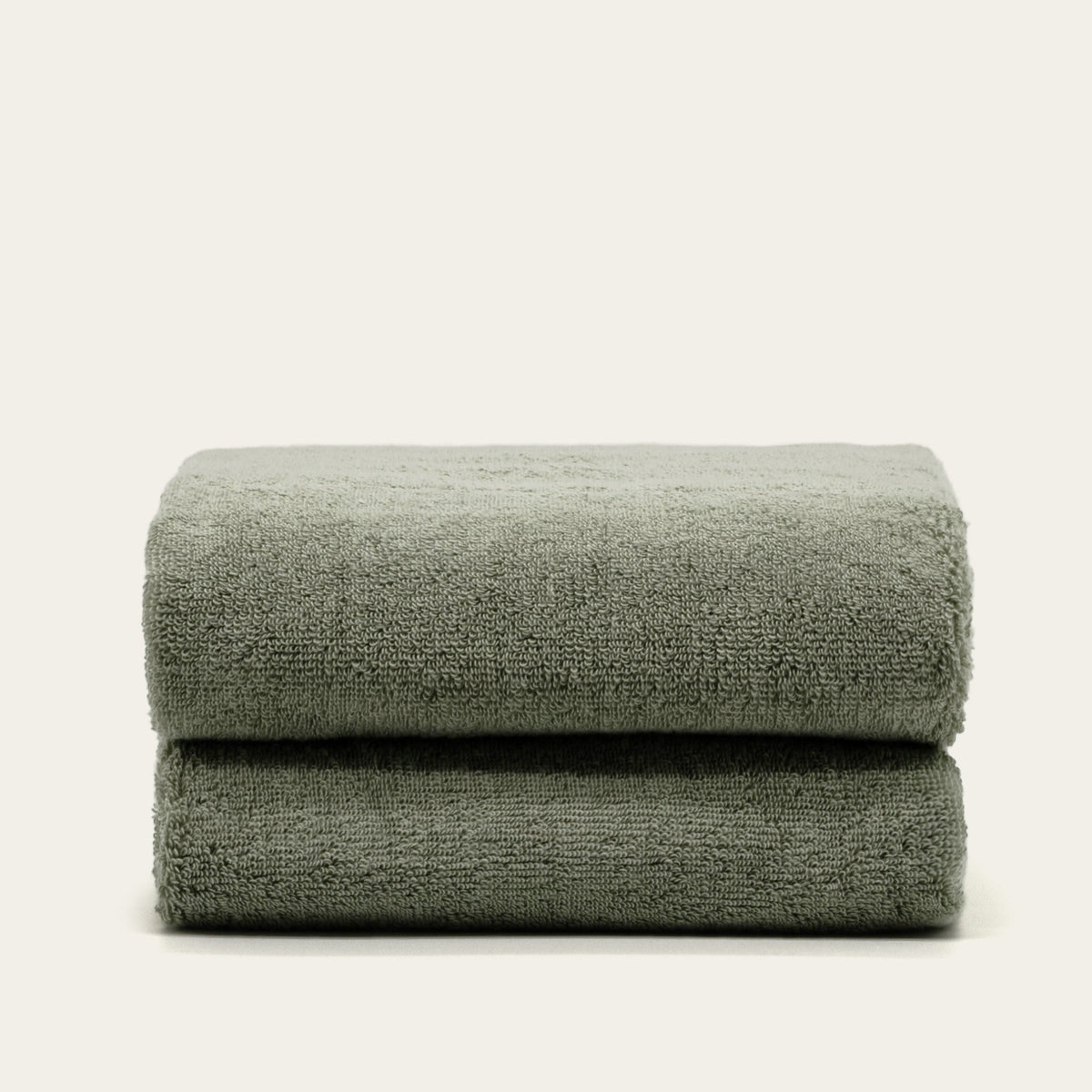 Sage green cotton towels, two folded layers, plush terry texture
