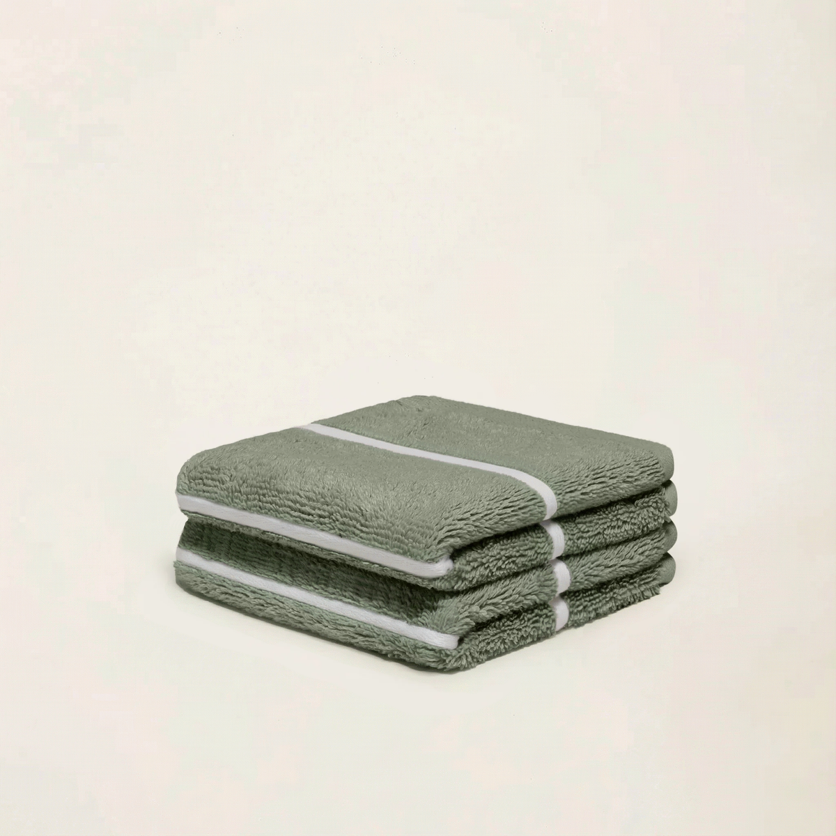 Sage green cotton towels with ecru stripes, folded in a small stack