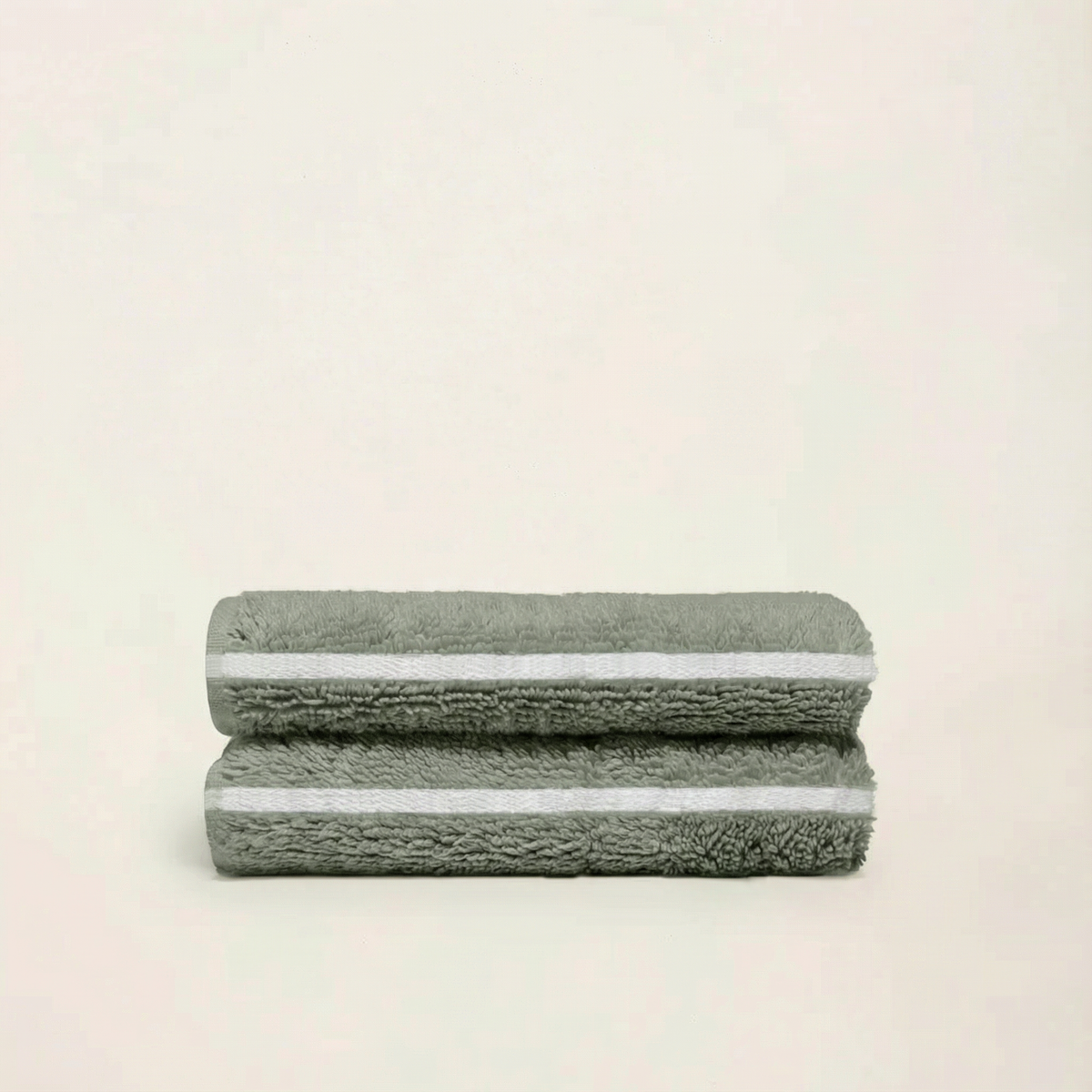 Sage green cotton towels with ecru border stripes, folded into two layers