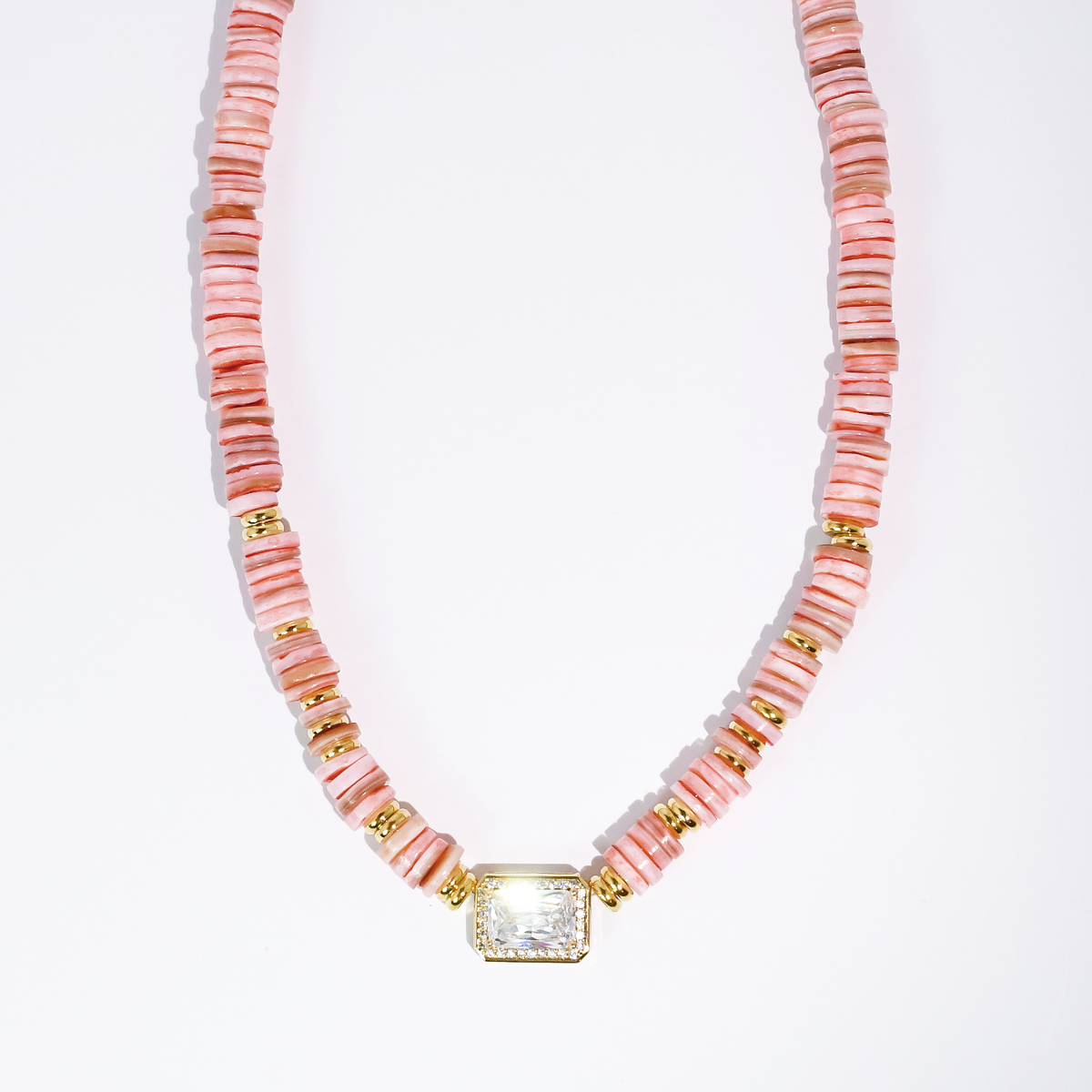 Coral pink heishi beaded necklace with gold-toned square gem pendant and ribbed spacer beads.