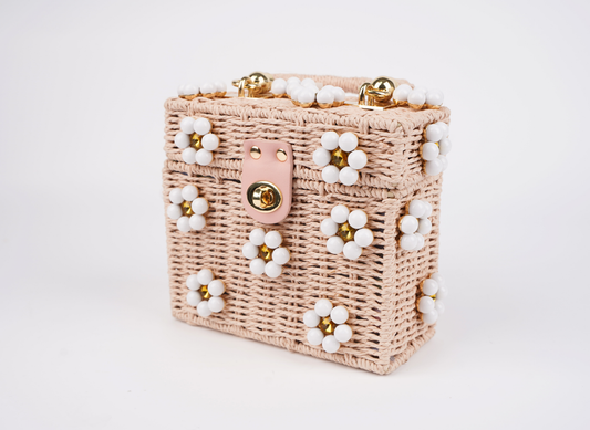 Pink woven handbag with beaded flower trim and gold clasp, side angle