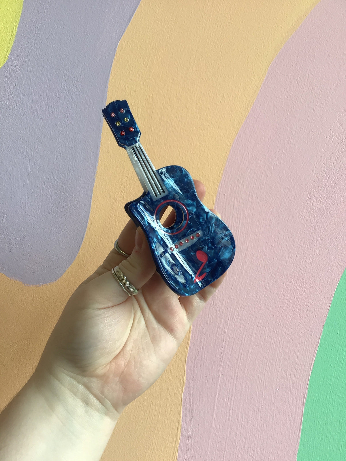 Blue electric guitar hair claw with red studs and reflective glossy finish