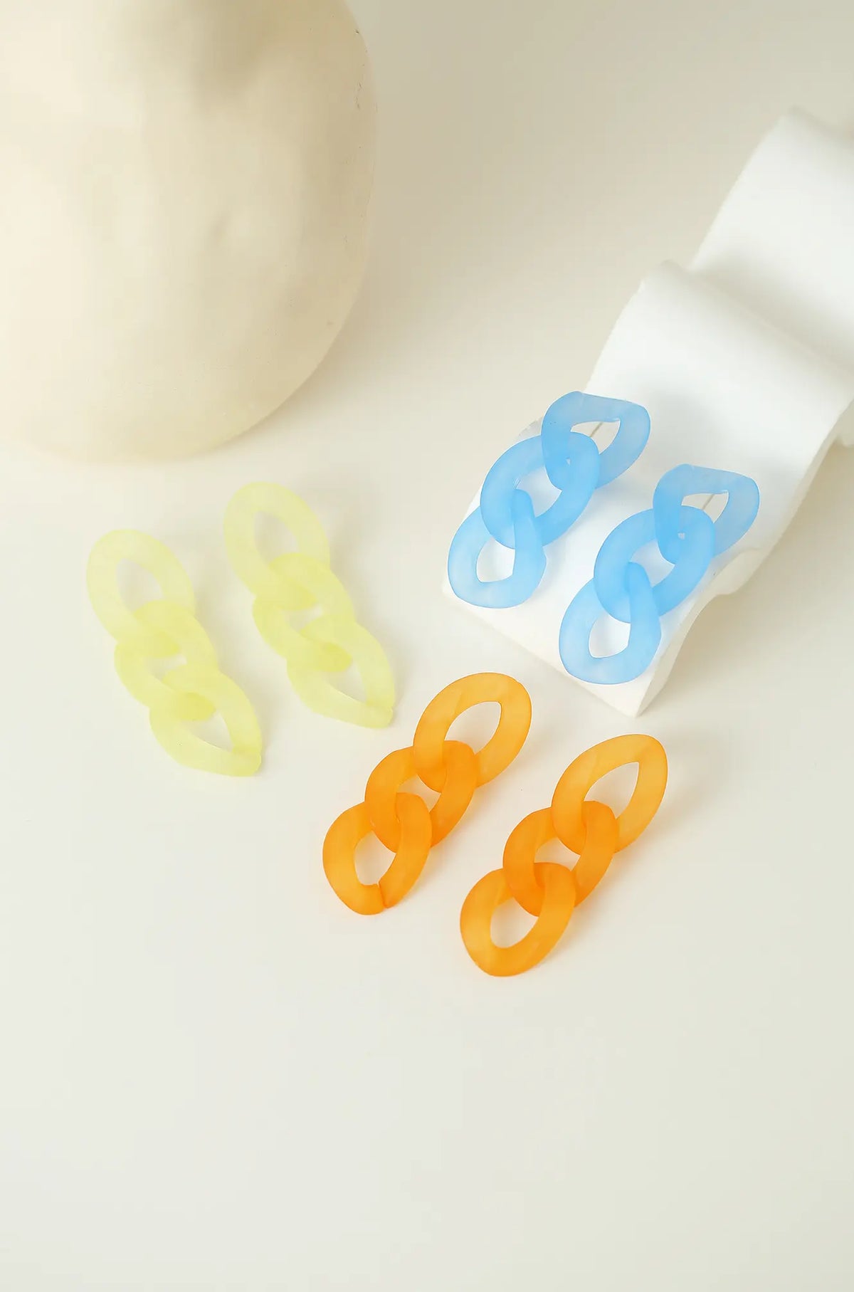 Three-link earrings in light blue, pale yellow, and orange