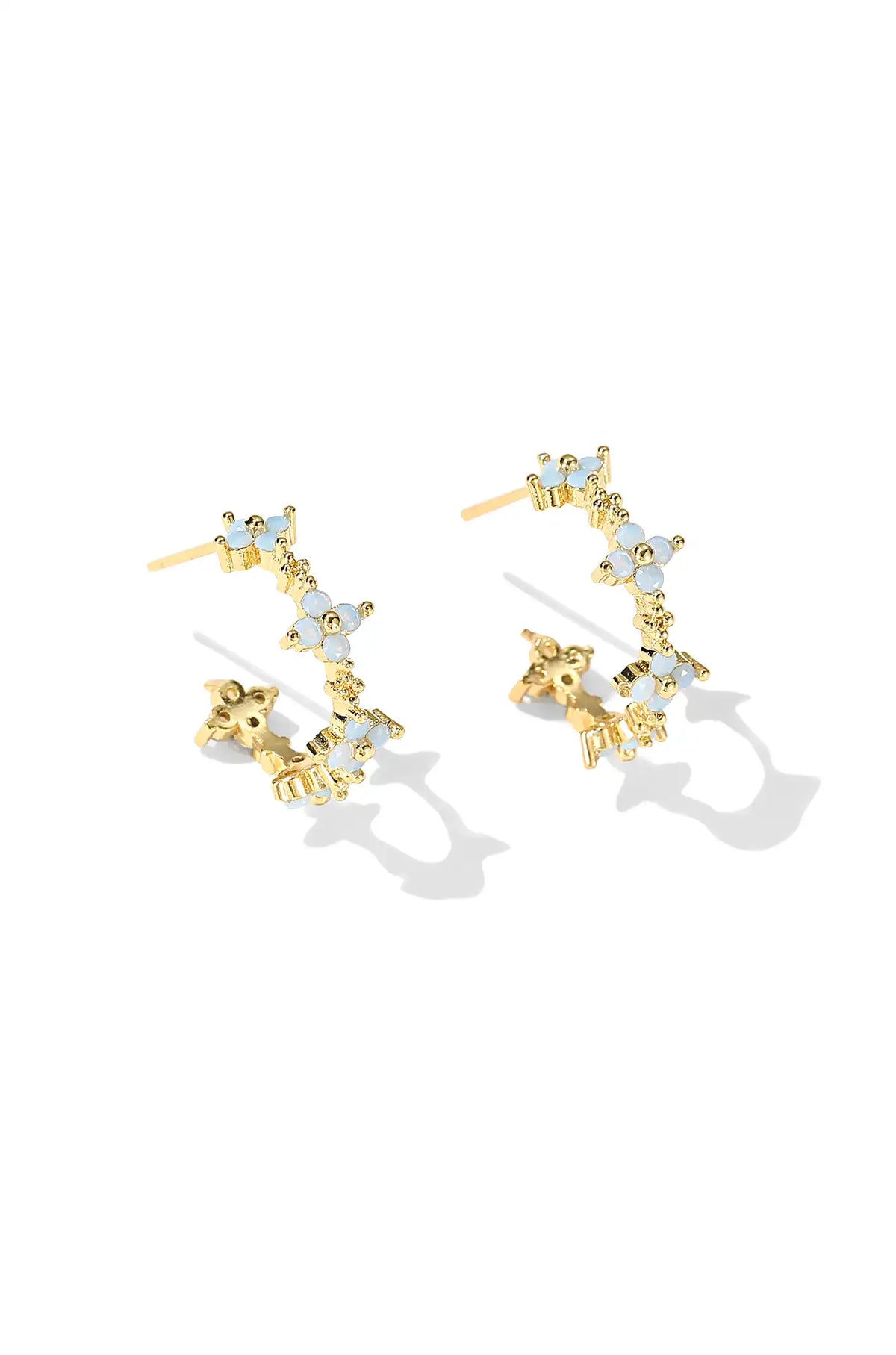 Gold flower hoop earrings with pale blue stones and clear accents
