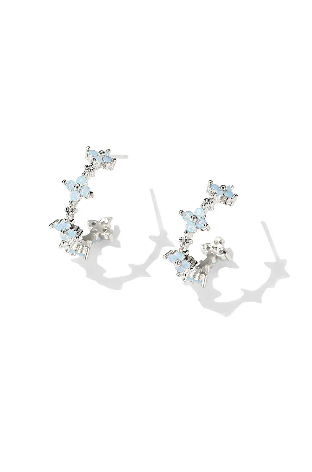 White gold flower hoop earrings with pale blue stones and clear accents