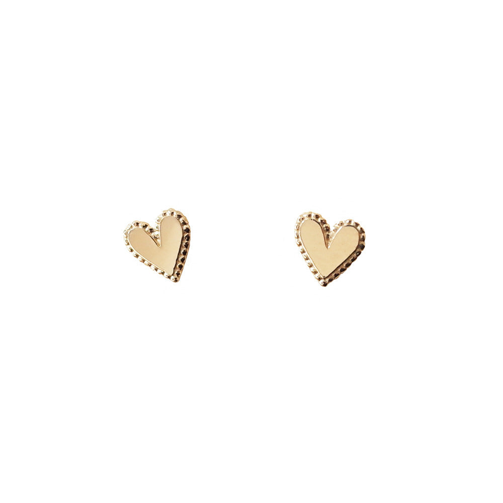 Gold heart stud earrings with dotted borders and smooth centers
