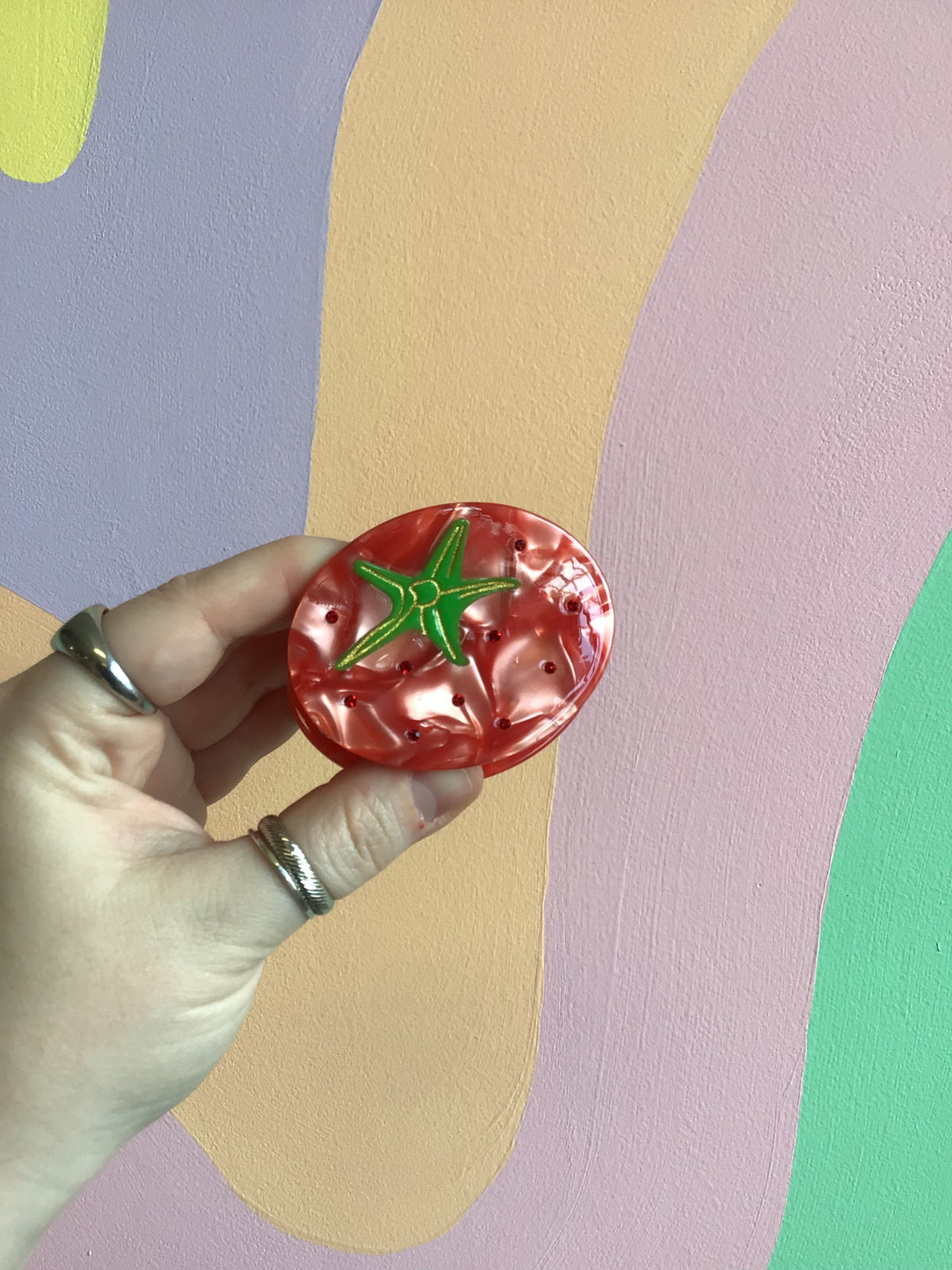 Red tomato-shaped hair claw with green leaf detail