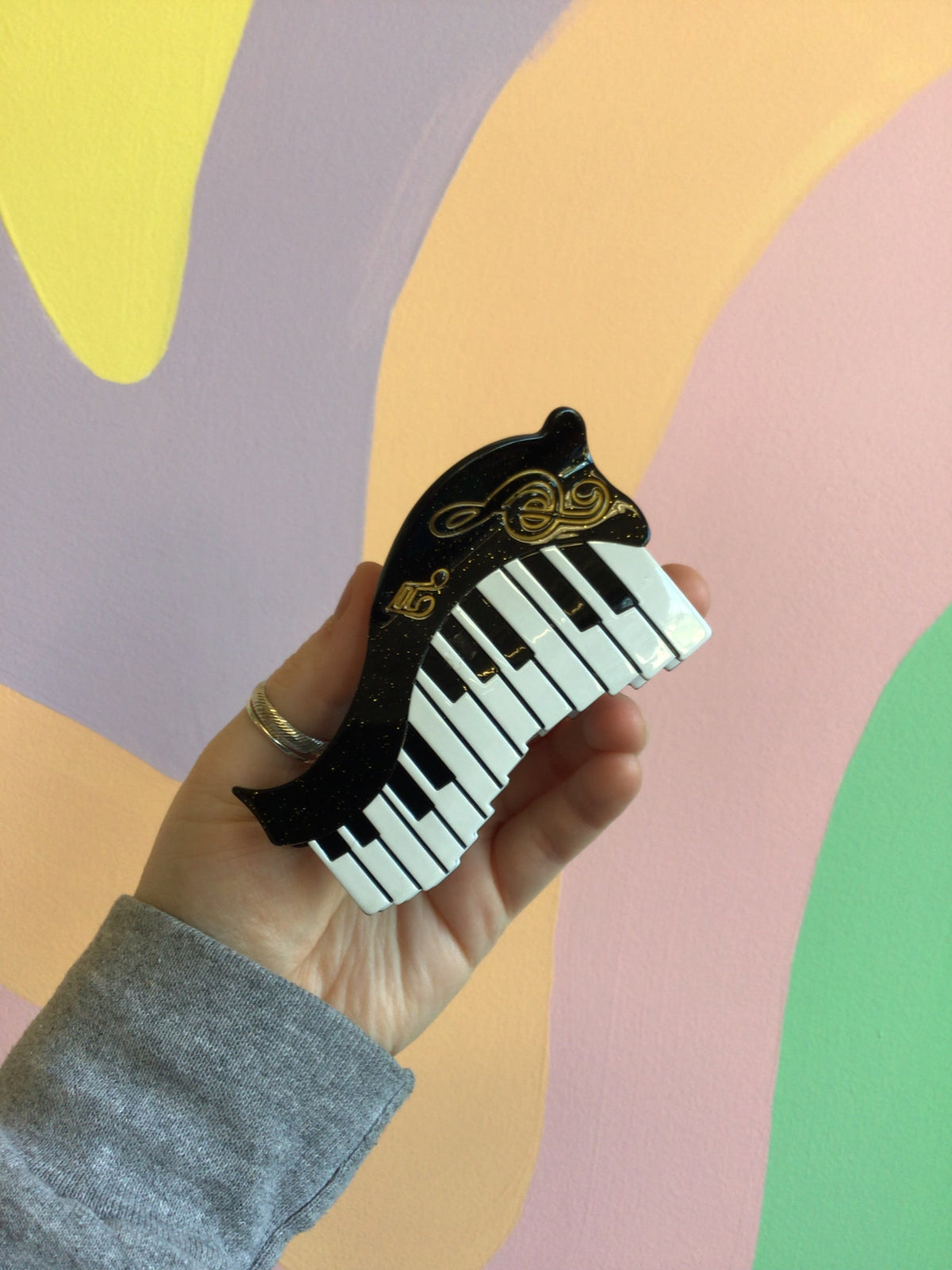 Piano keyboard hair claw with black outline and gold decorative detailing