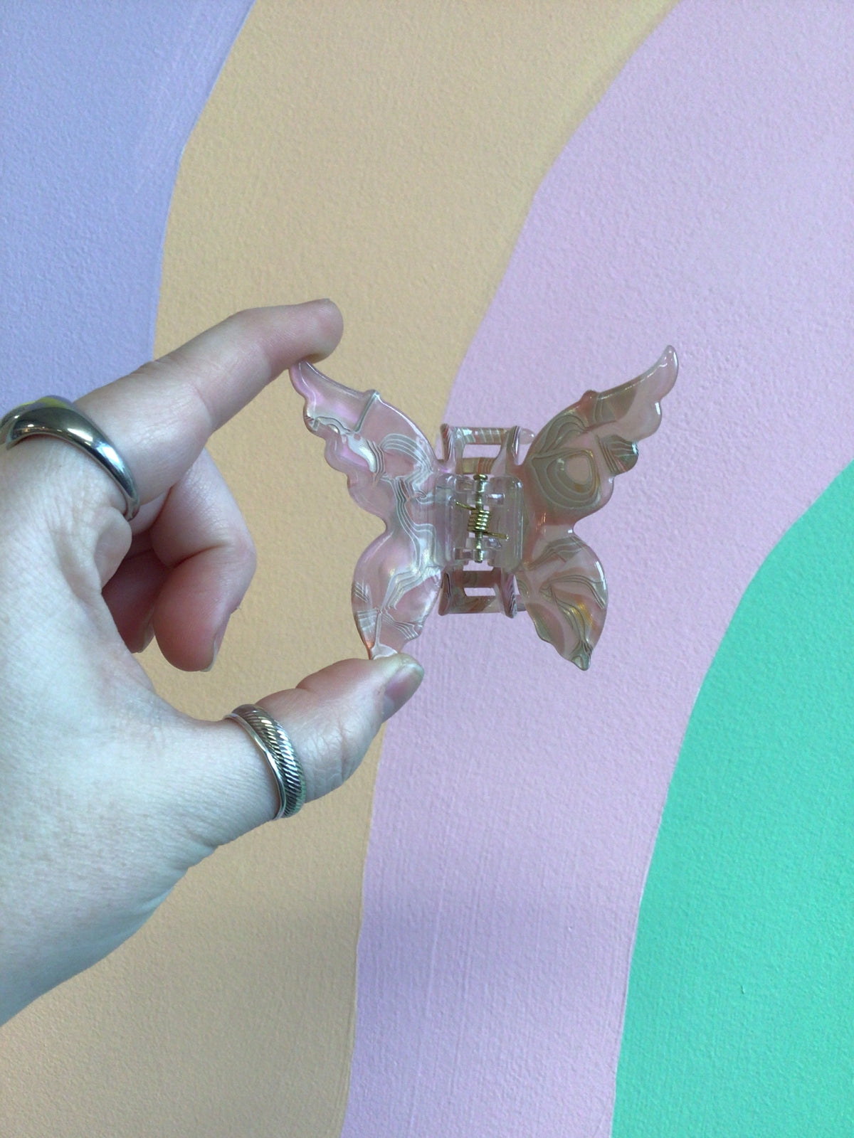 Butterfly hair claw with translucent pink iridescent wings and metal hinged clip