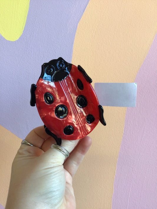 Red beetle hair claw with black spots and curved black side clips