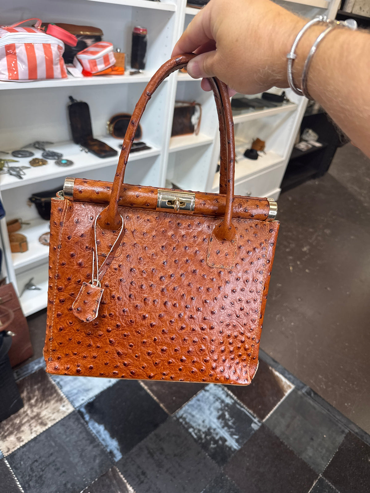 Sonya bag in cognac with textured leather, double handles, top clasp, and hanging tag