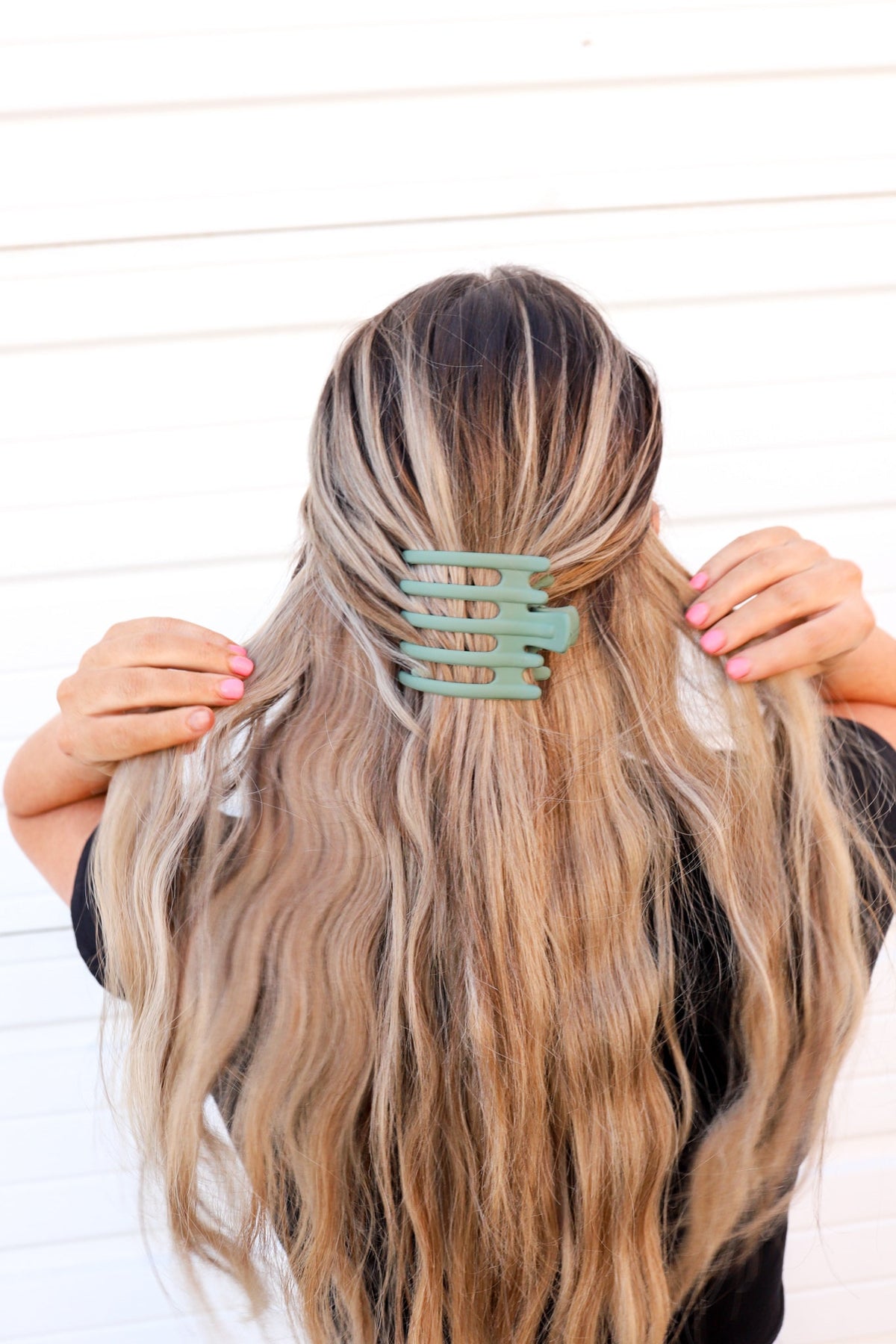 Wide hair claw clip in teal green, holding long hair at the back