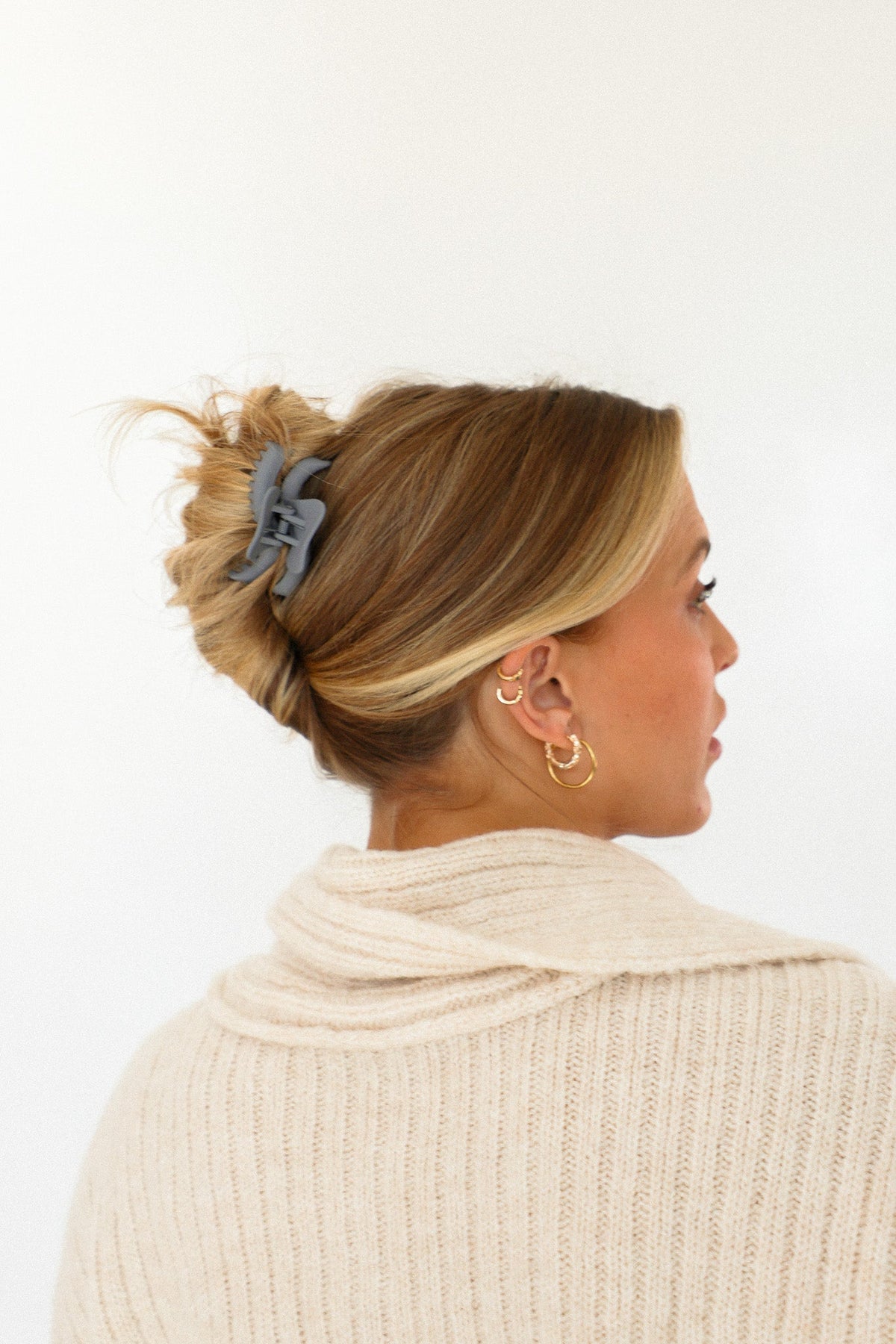 Wavy mini hair claw clip with light blue color, securing hair in a bun.