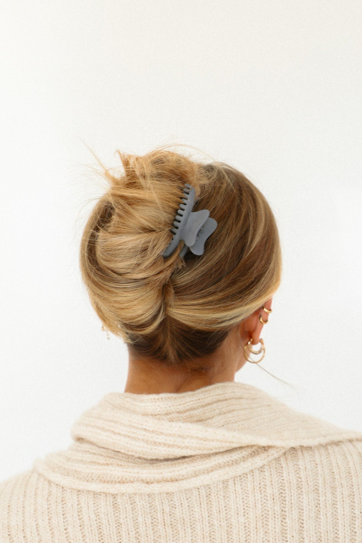 Wavy mini hair claw clip with light blue design, holding a messy bun.