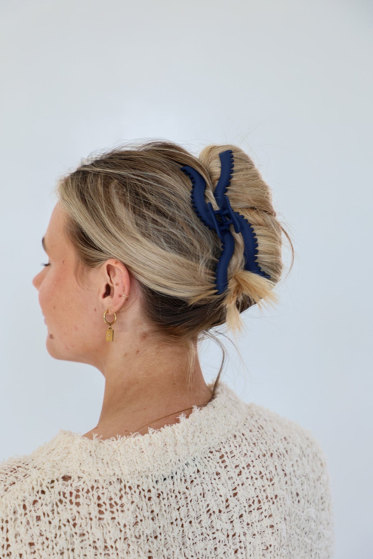Dark blue wavy hair claw securing blonde hair bun