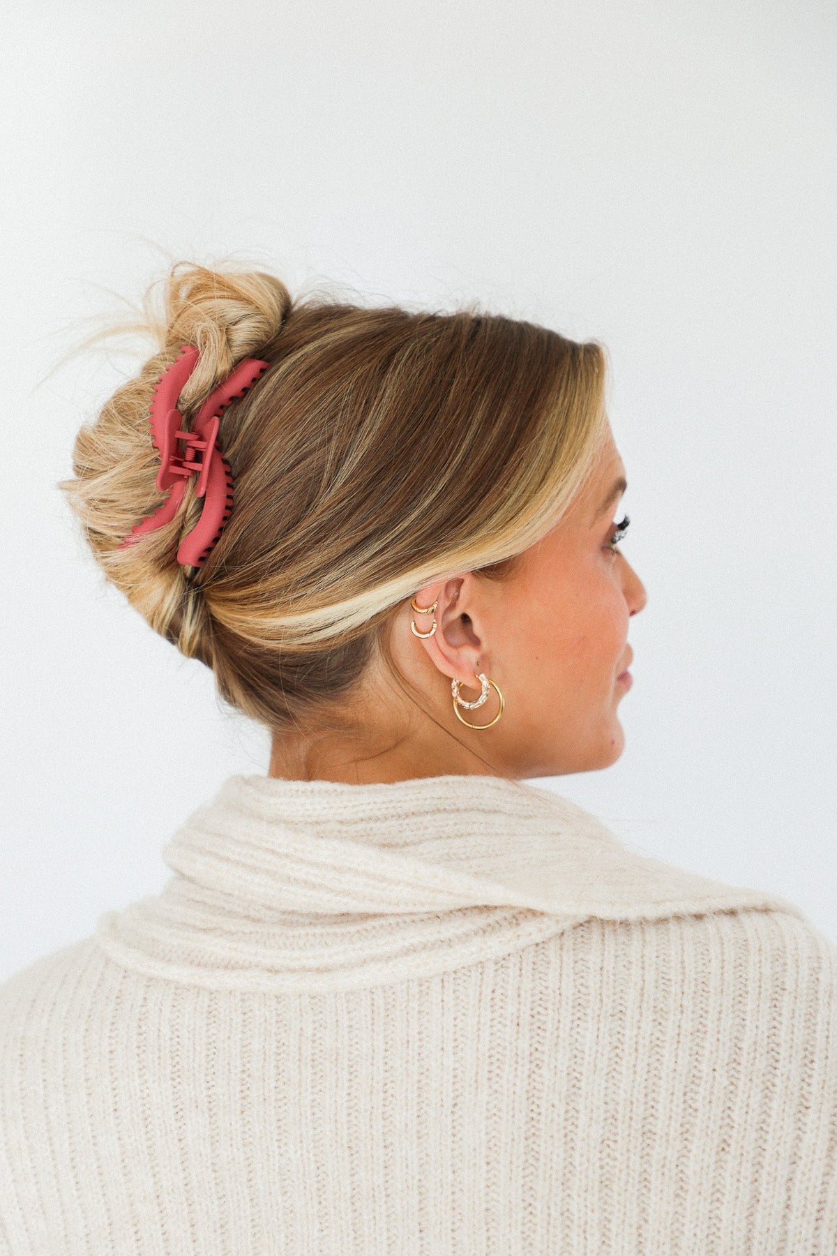 Red wavy hair claw clip holding blonde hair bun