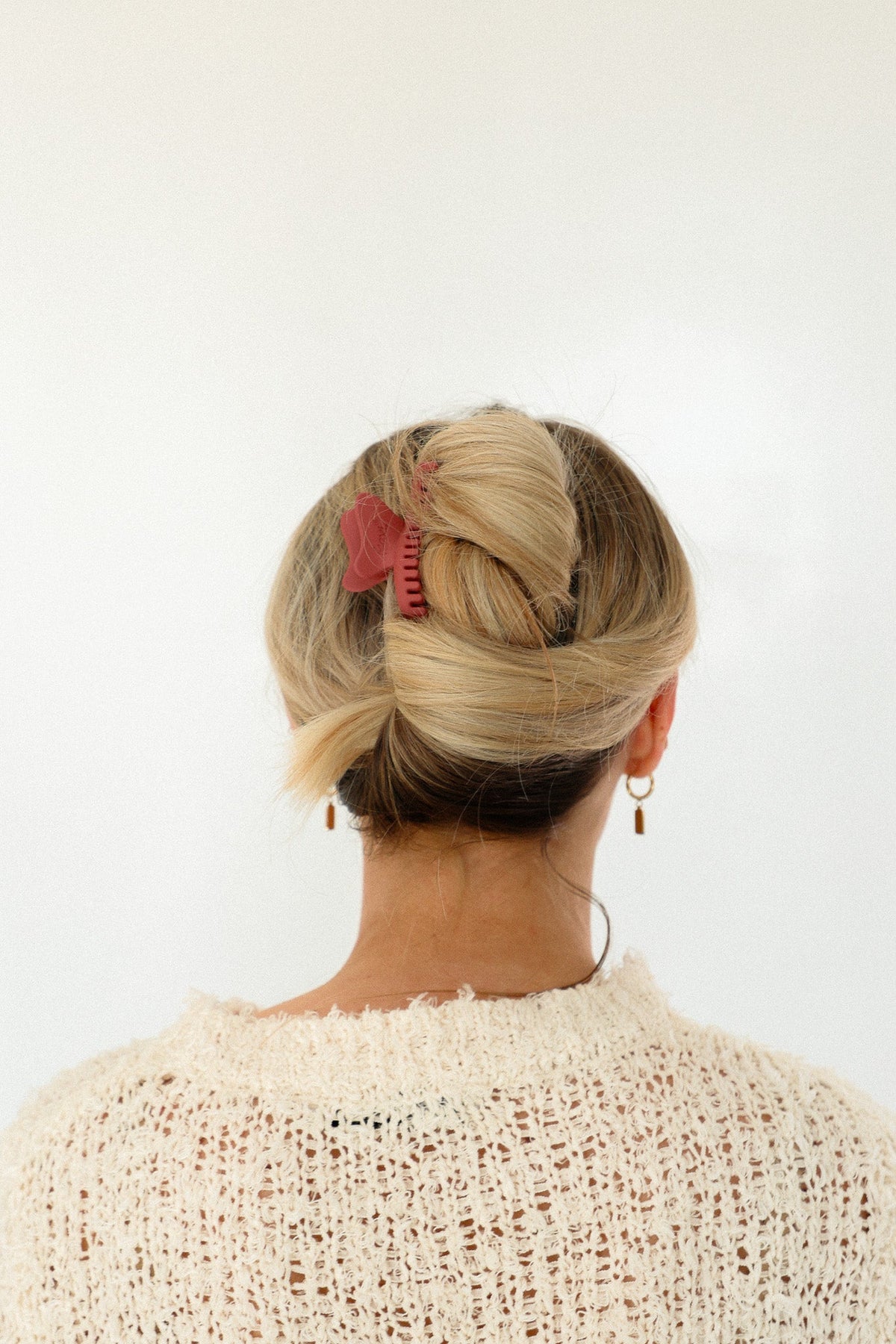 Red mini claw hair clip on blonde bun from behind