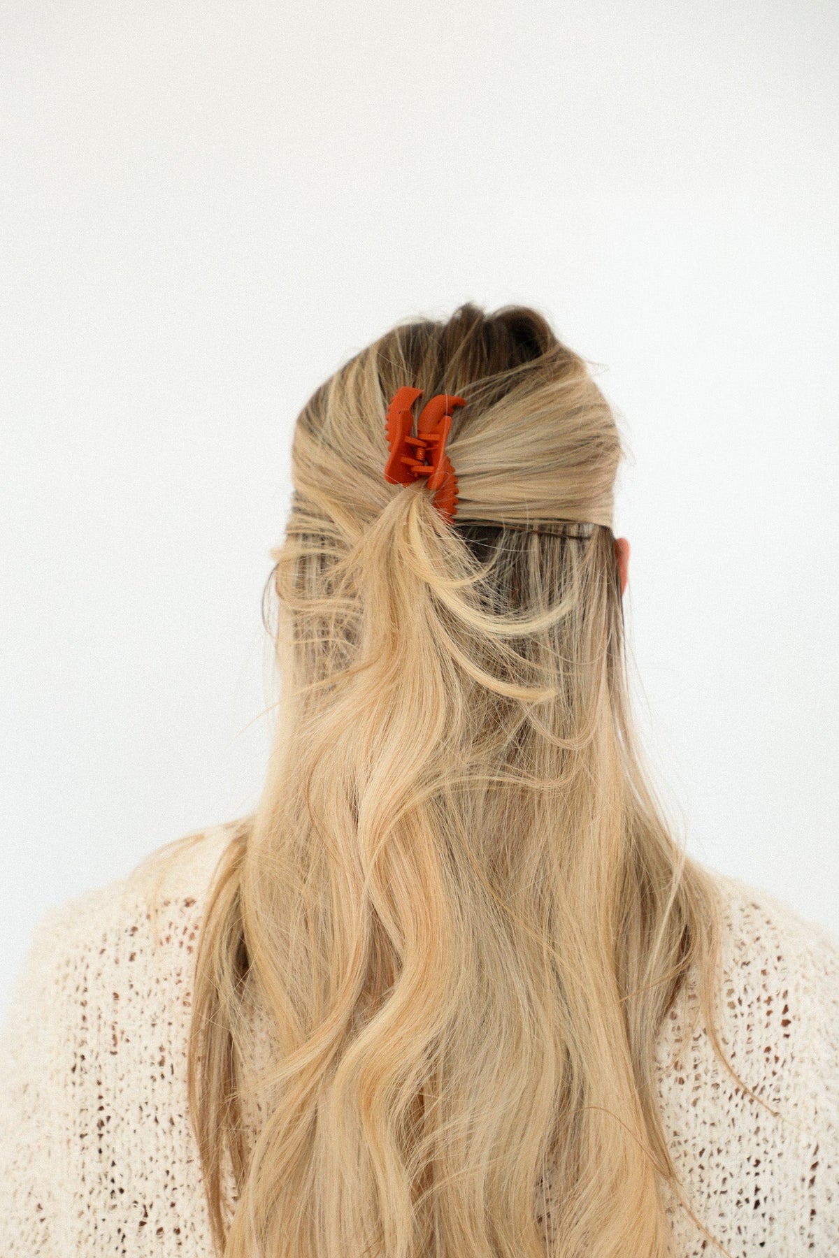 Orange mini claw hair clip holding long blonde hair up