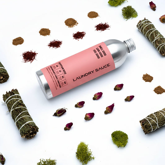 Performance laundry fabric softener bottle with pink label, surrounded by dried botanicals