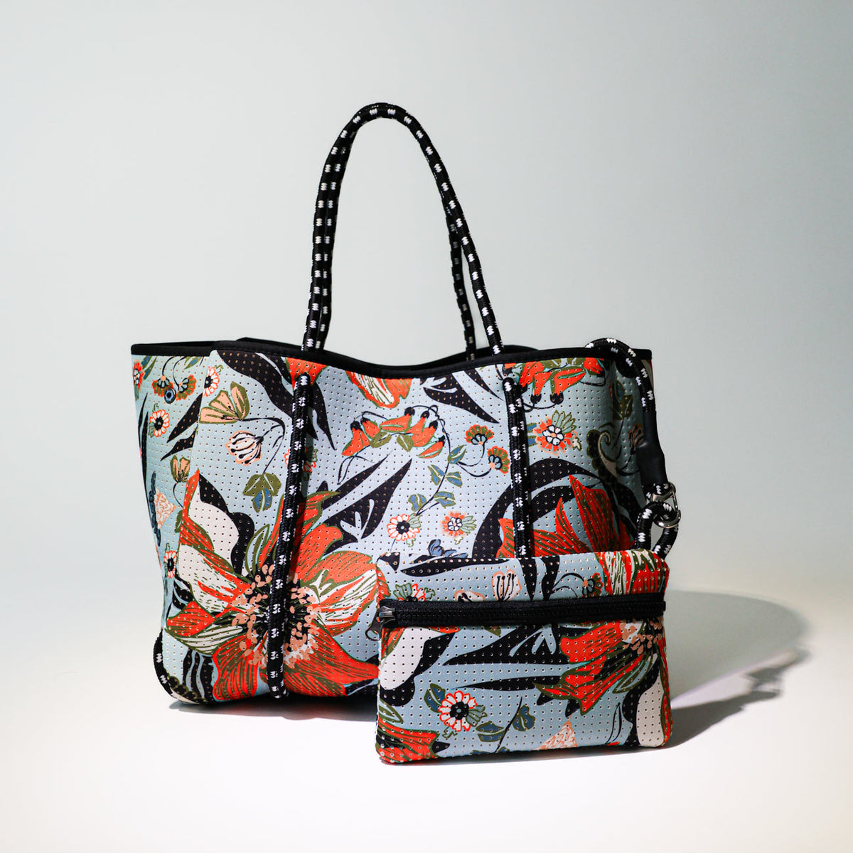 Printed floral tote bag with black handles and side seams, open top