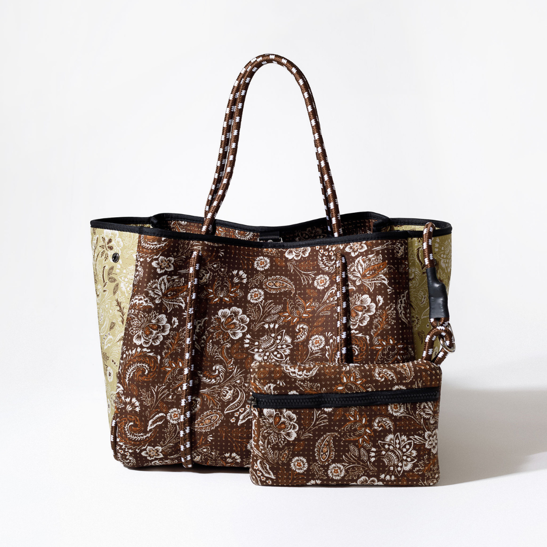 Paisley tote bag with dark trim, striped handles, and matching zip pouch