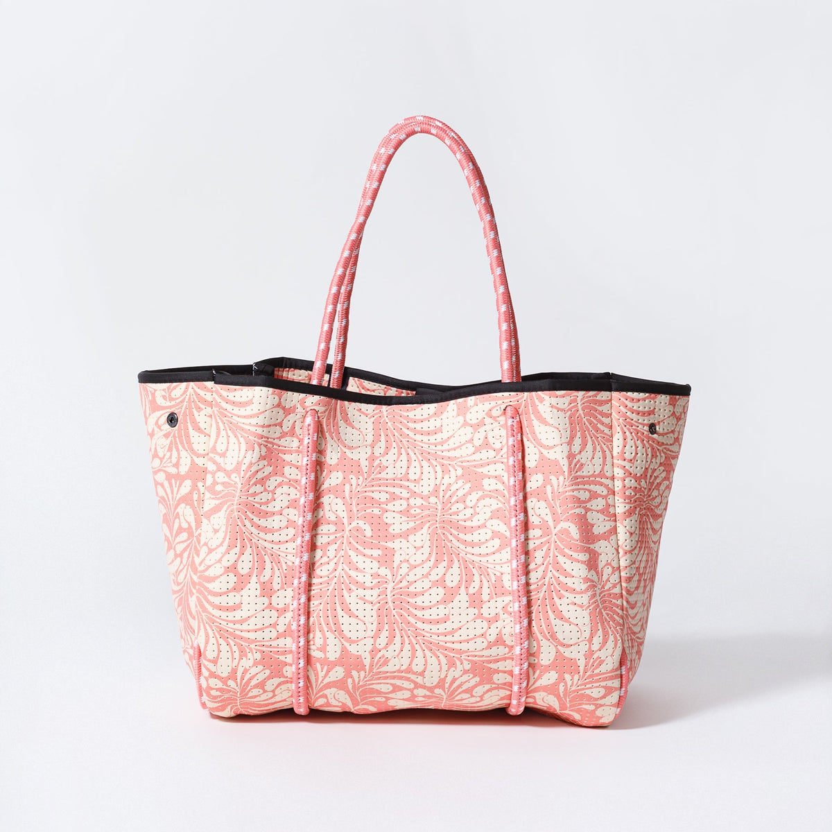 Pink palm-leaf print tote bag with black trim and pink rope handles