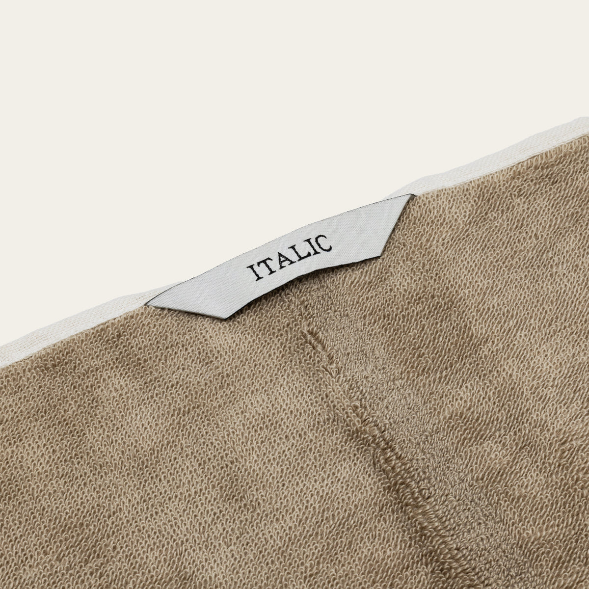 Tan and ecru cotton towel with white stripe accents and sewn ITALIC label