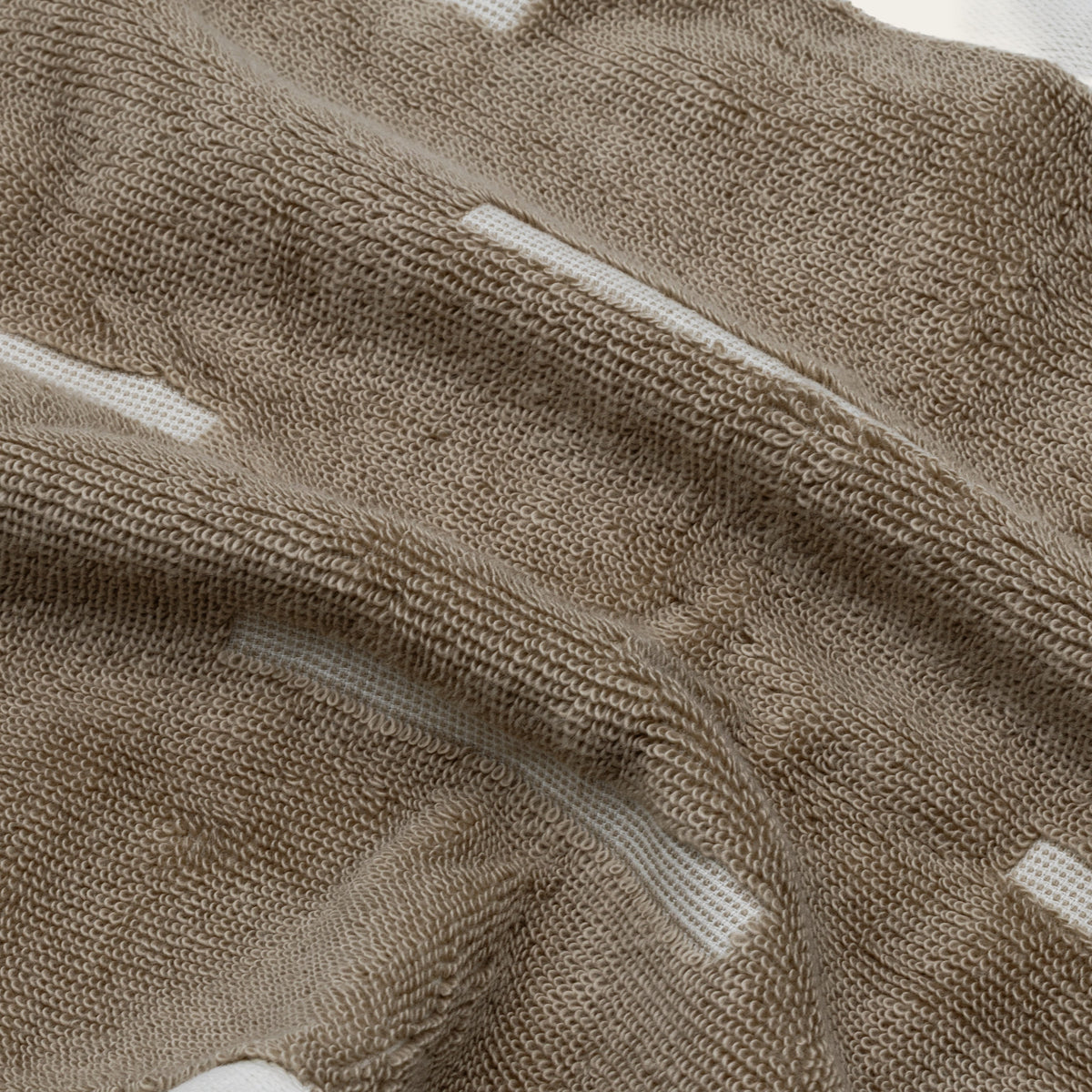 Close-up of tan and ecru cotton towel texture with white stripe detail