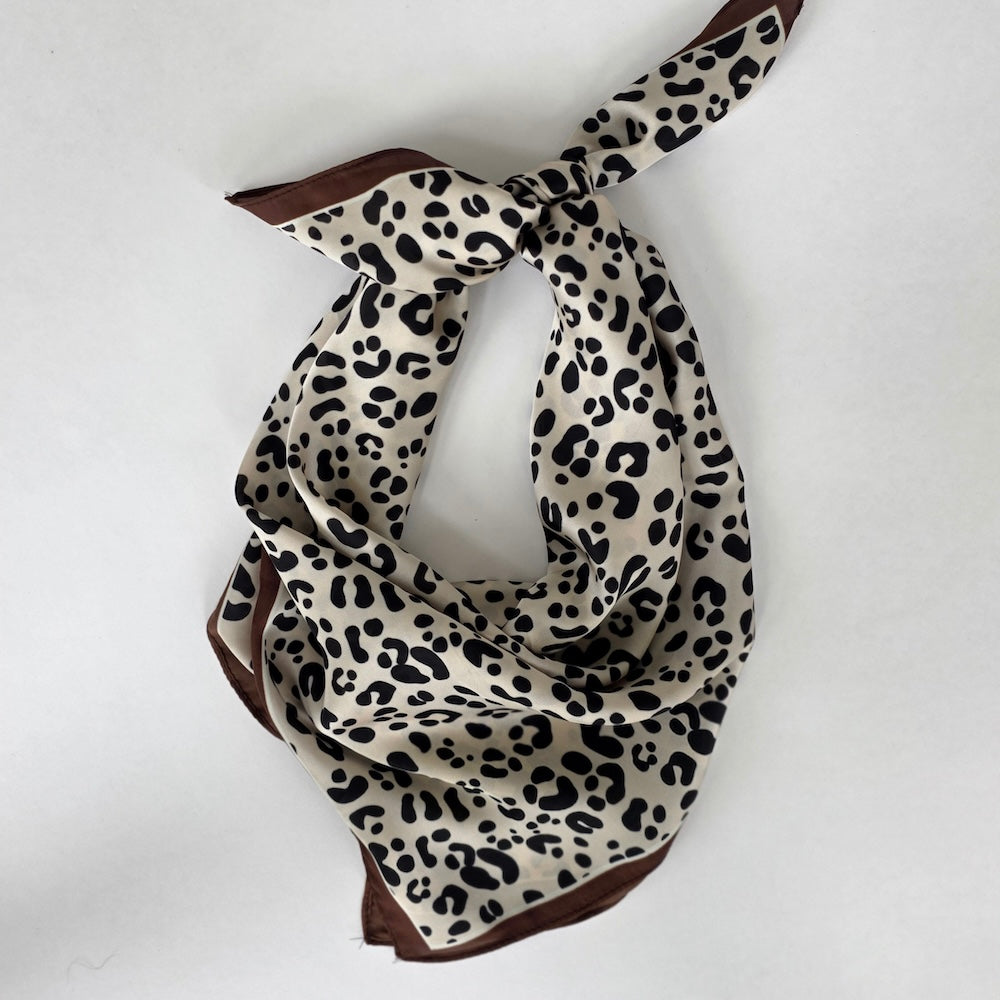 Leopard print square scarf, looped and knotted with brown and cream tones