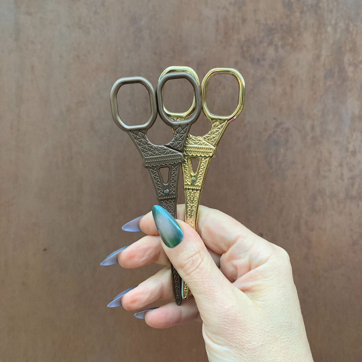 Set of Eiffel Tower mini scissors in three metallic colors, held together, two loops each.