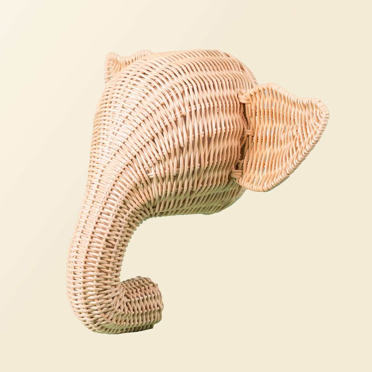Side view of a woven elephant wall hook with curled trunk