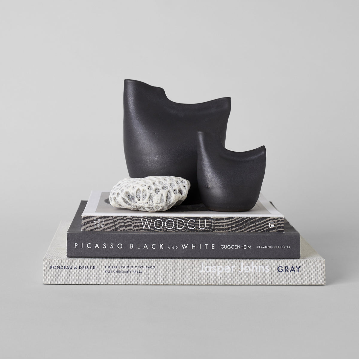 Matte black bird vase trio with staggered sizes and smooth curved lip openings.
