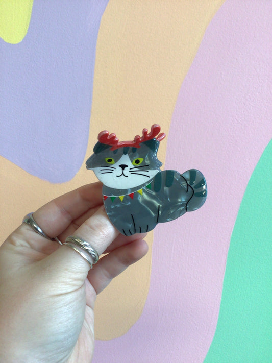 Festive cat hair claw with grey cat figure and red crown-like headpiece