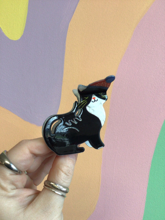 Festive cat hair claw with black cat figure and dark blue hat detail