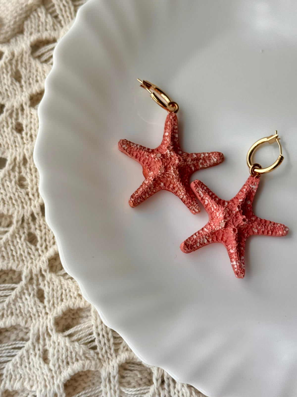 Red starfish hoop earrings with gold-tone loops