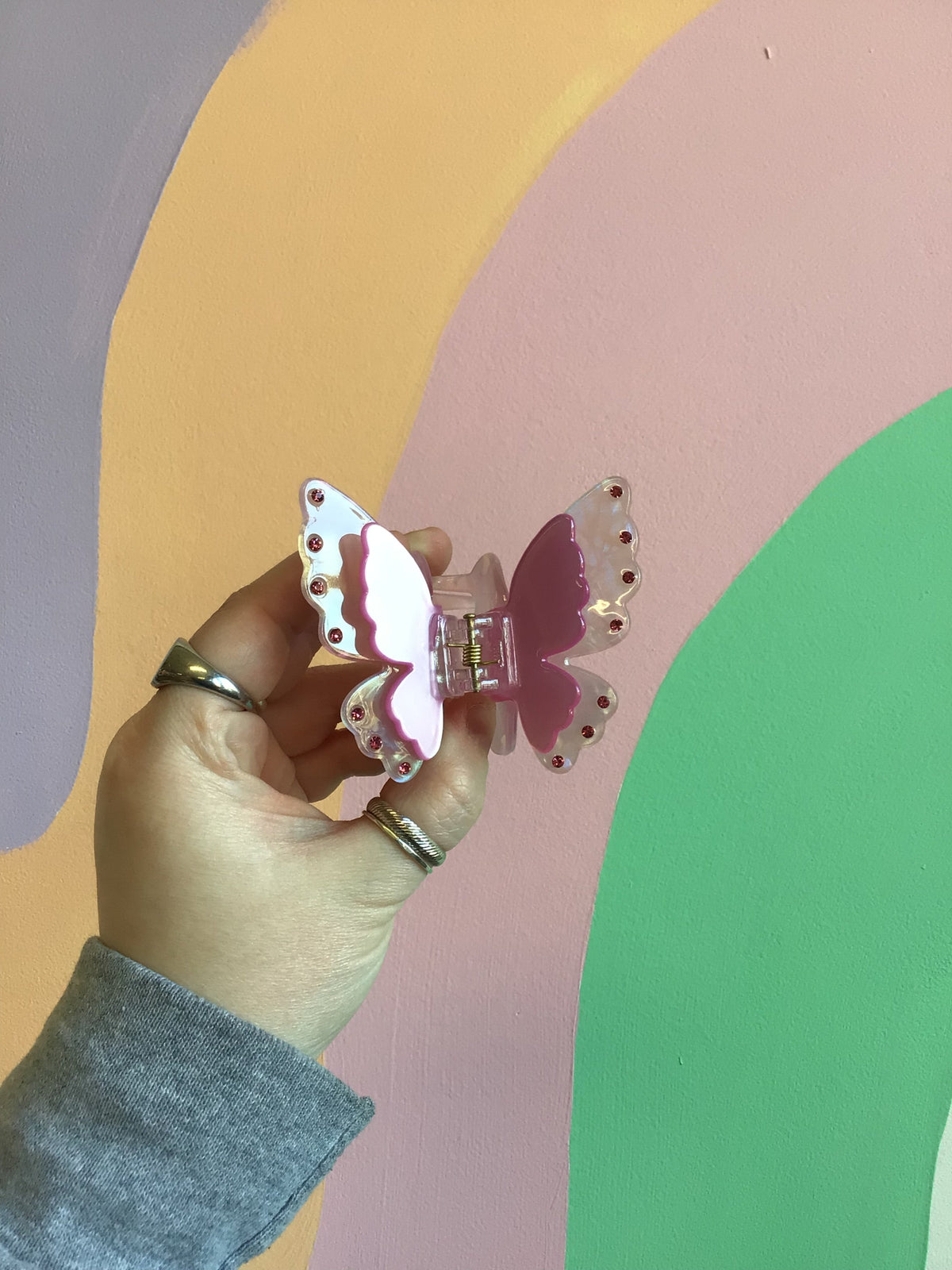 Butterfly hair claw with rosy-and-white wings, jeweled edge, and silver comb clip