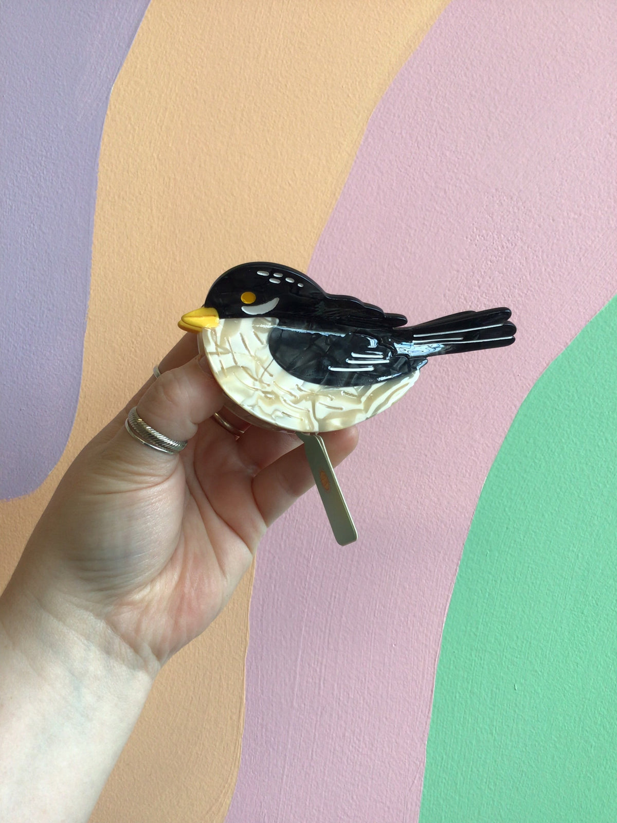 Black bird hair claw with yellow beak and cream belly stripe
