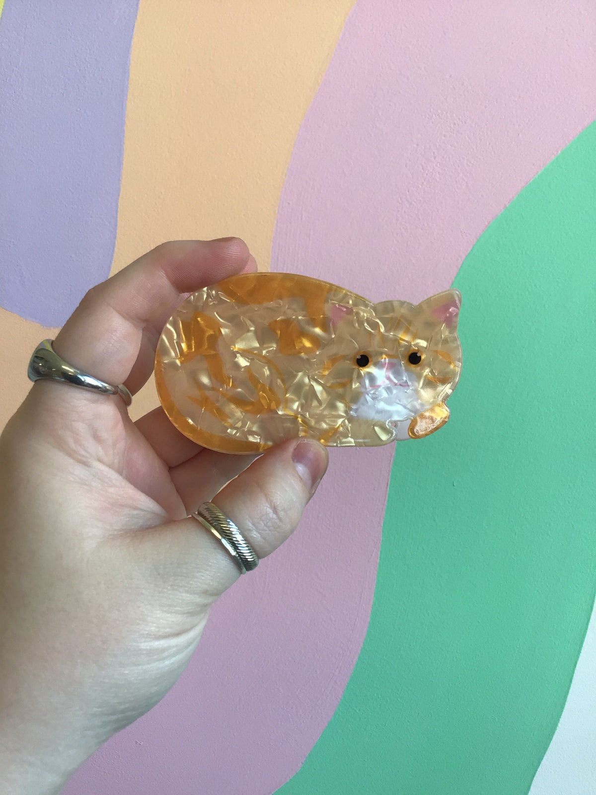 Clear amber orange cat hair claw with orange stripes and small black eyes
