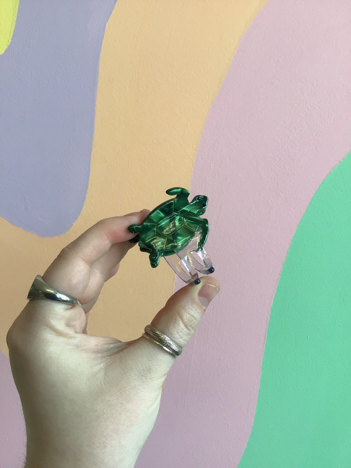 Green turtle-shaped hair claw with translucent shell and curved clips