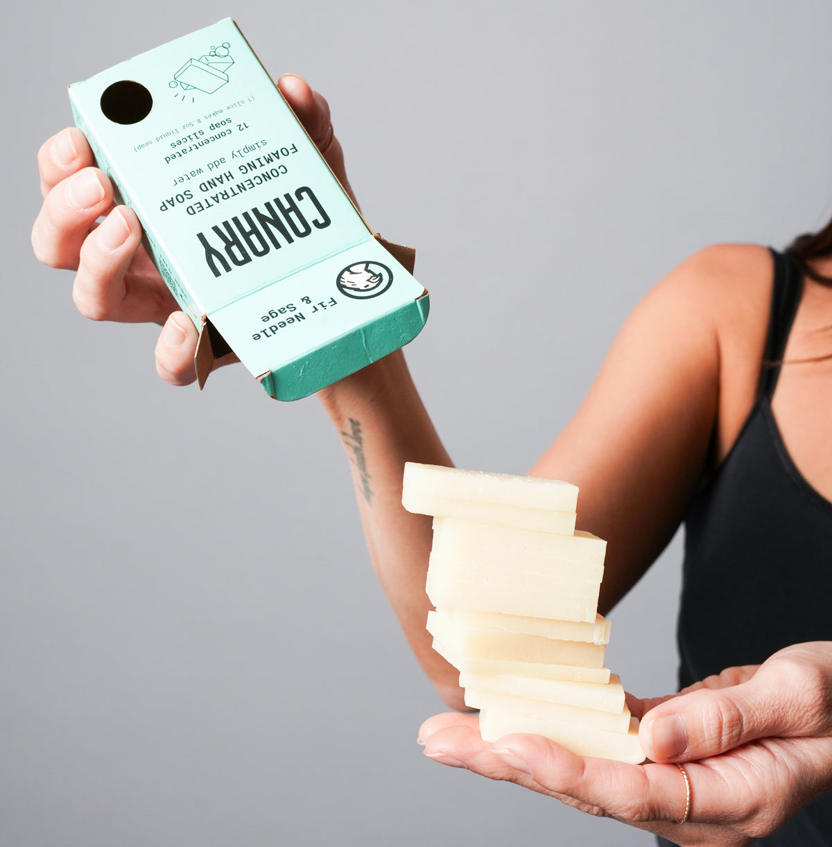 Fir Needle and Sage soap refill box beside a stack of pale soap slices
