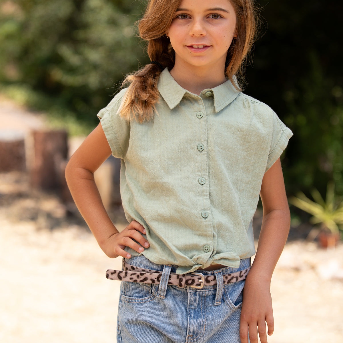Beige leopard print belt worn with jeans and a tied shirt