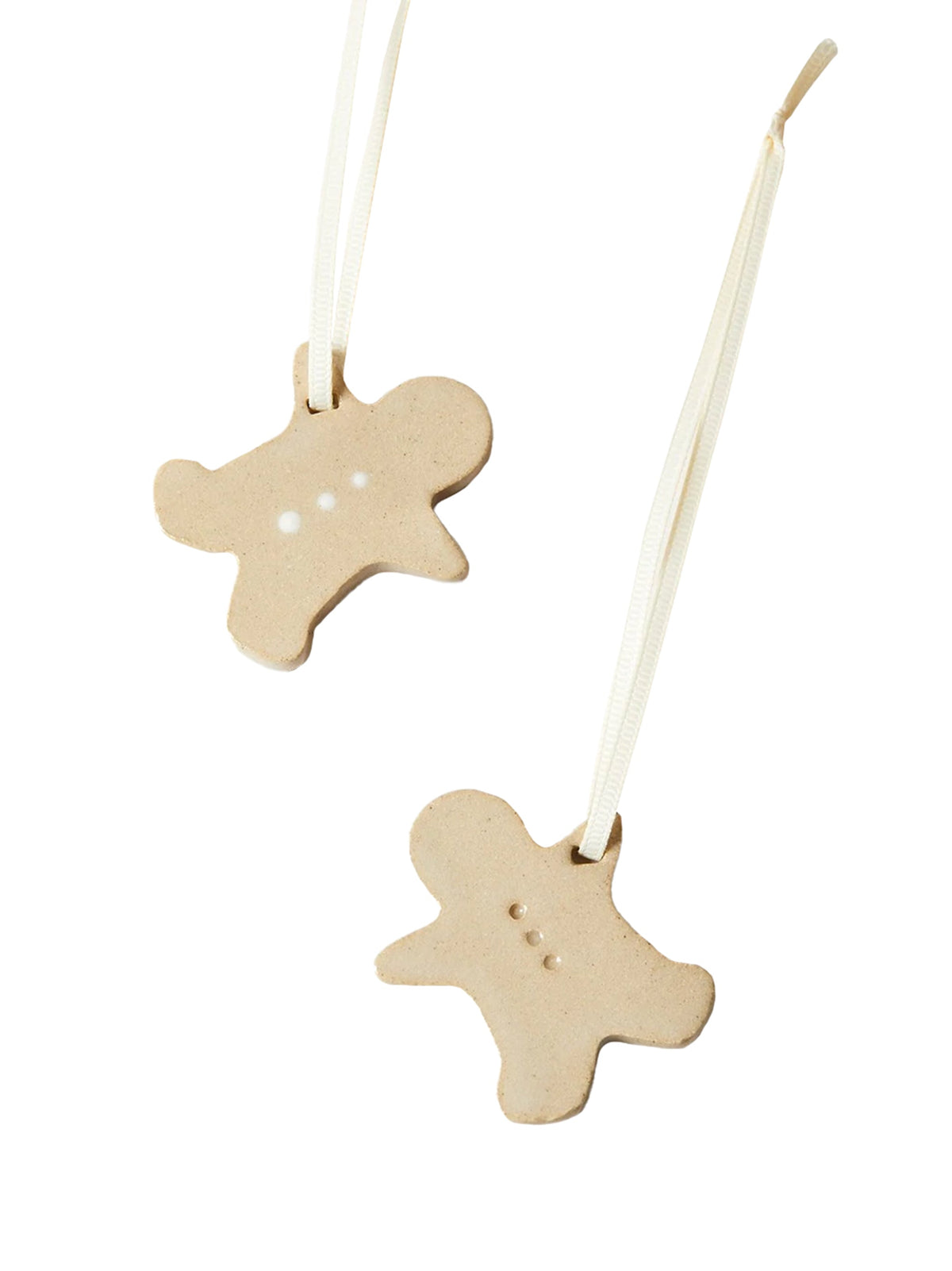 Pair of beige gingerbread-shaped ornaments with hanging strings and dotted details