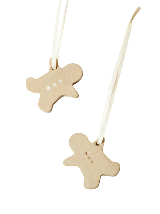 Pair of beige gingerbread-shaped ornaments with hanging strings and dotted details