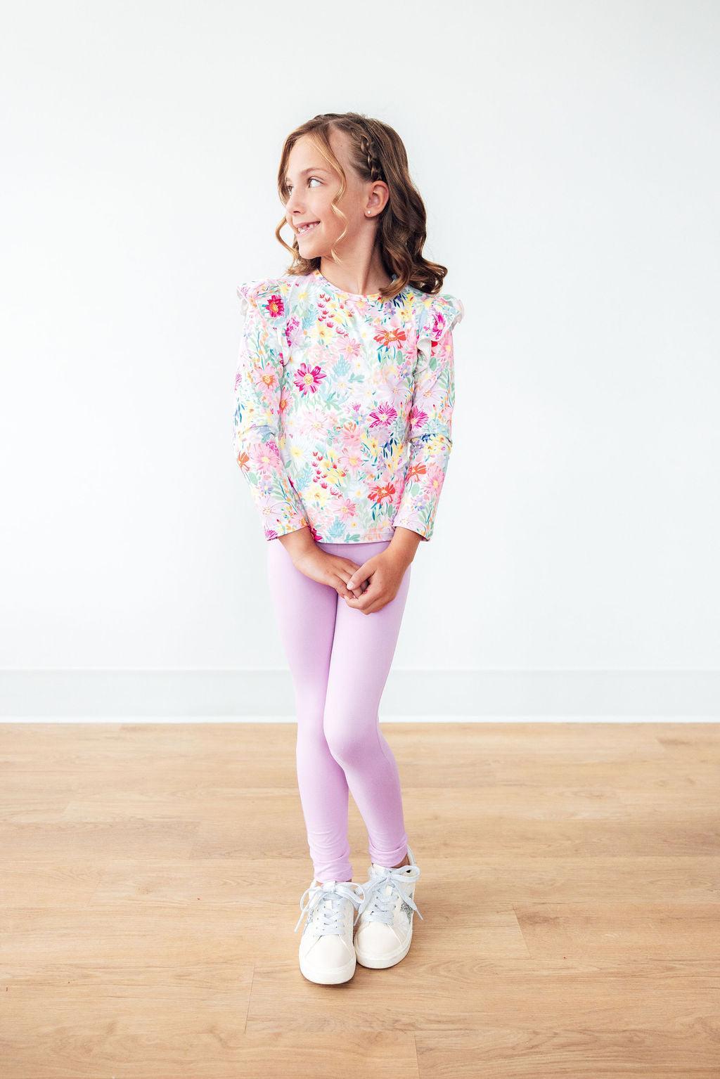 Girls long-sleeve ruffle tee in pastel floral print, model wearing with leggings