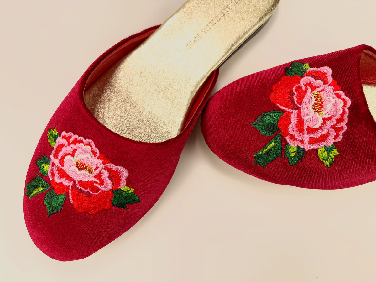 Red wine mule slippers with embroidered peony and green leaves, angled view